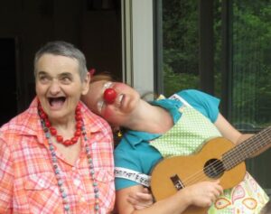 Tilotamma (Marie-Gabriele Massa) singt fröhlich mit einer alten Bewohnerin im Altenheim – Clownerie und Stimmarbeit in Merzig, Saarland
